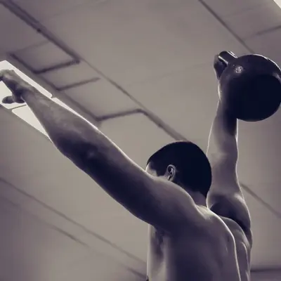 Athlète levant une kettlebell à bout de bras