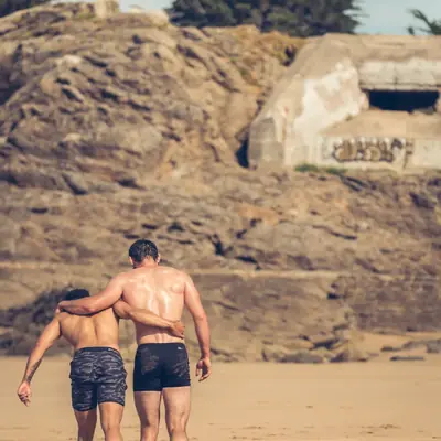 Deux sportifs épaule contre épaule après l’effort, sur la plage