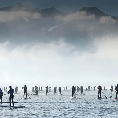 Course de paddle au pied des montagnes, dans la brume